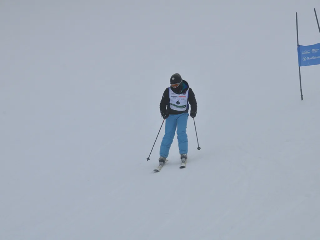 Skifahrer nähert sich dem blauen Tor im Nebel.
